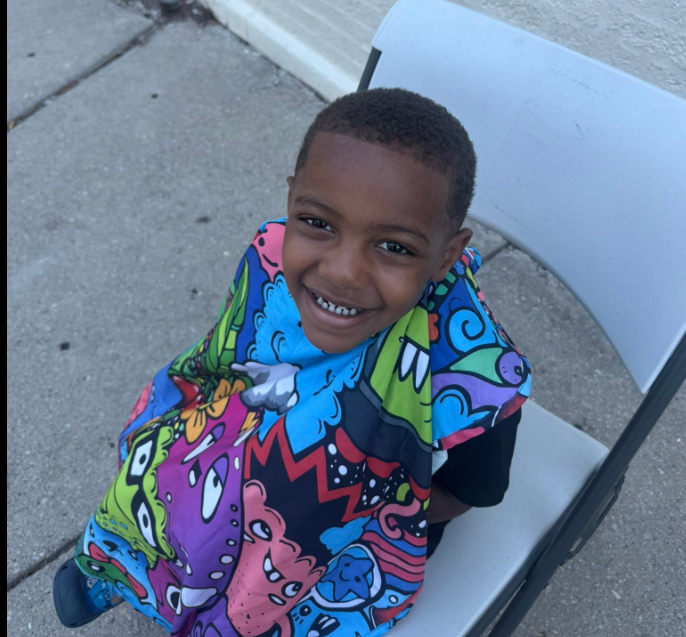 Barber giving free back-to-school haircut to a young child